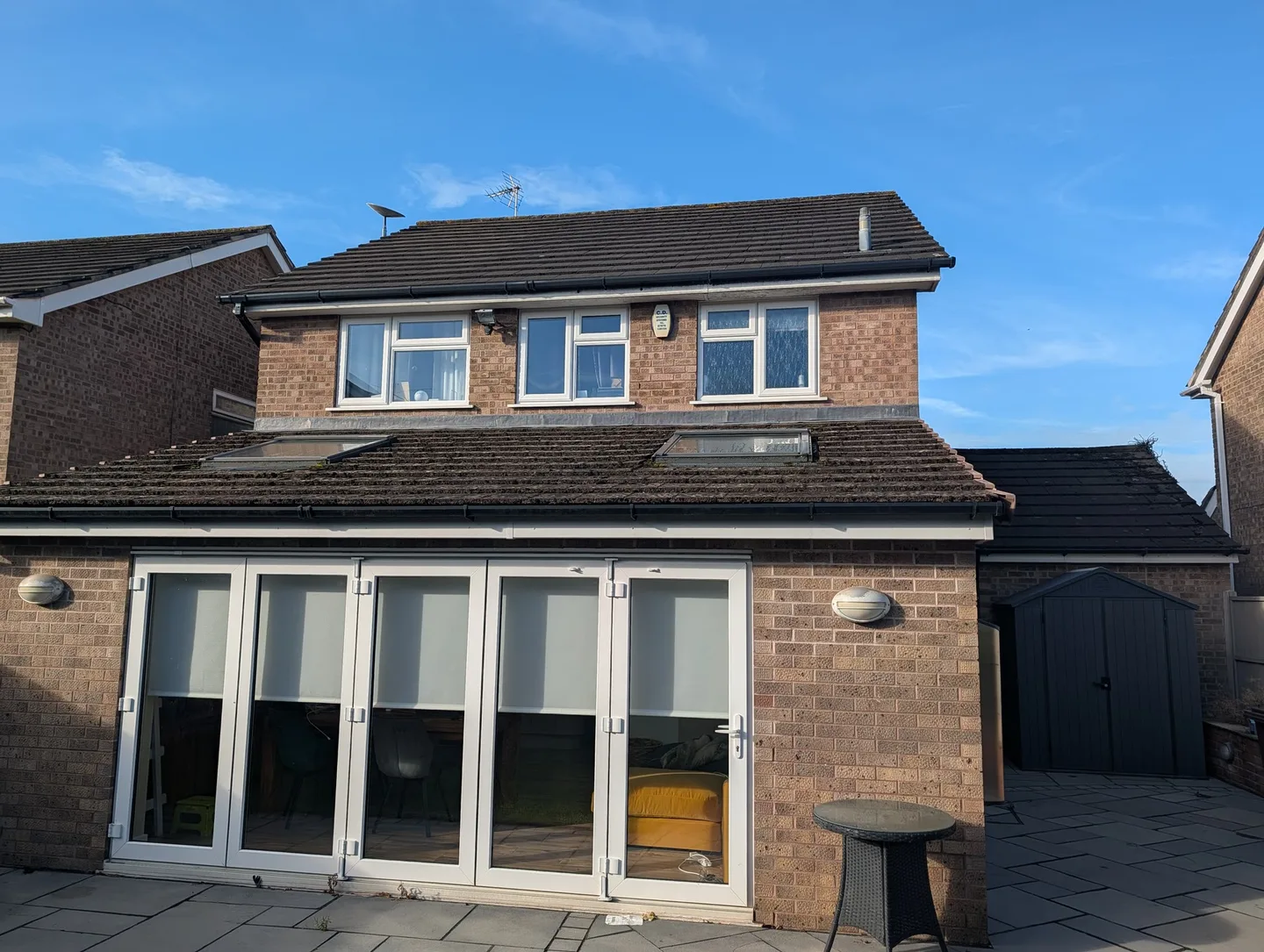 Wide view of the Tean house roof before cleaning, with moss visible across the tiles.