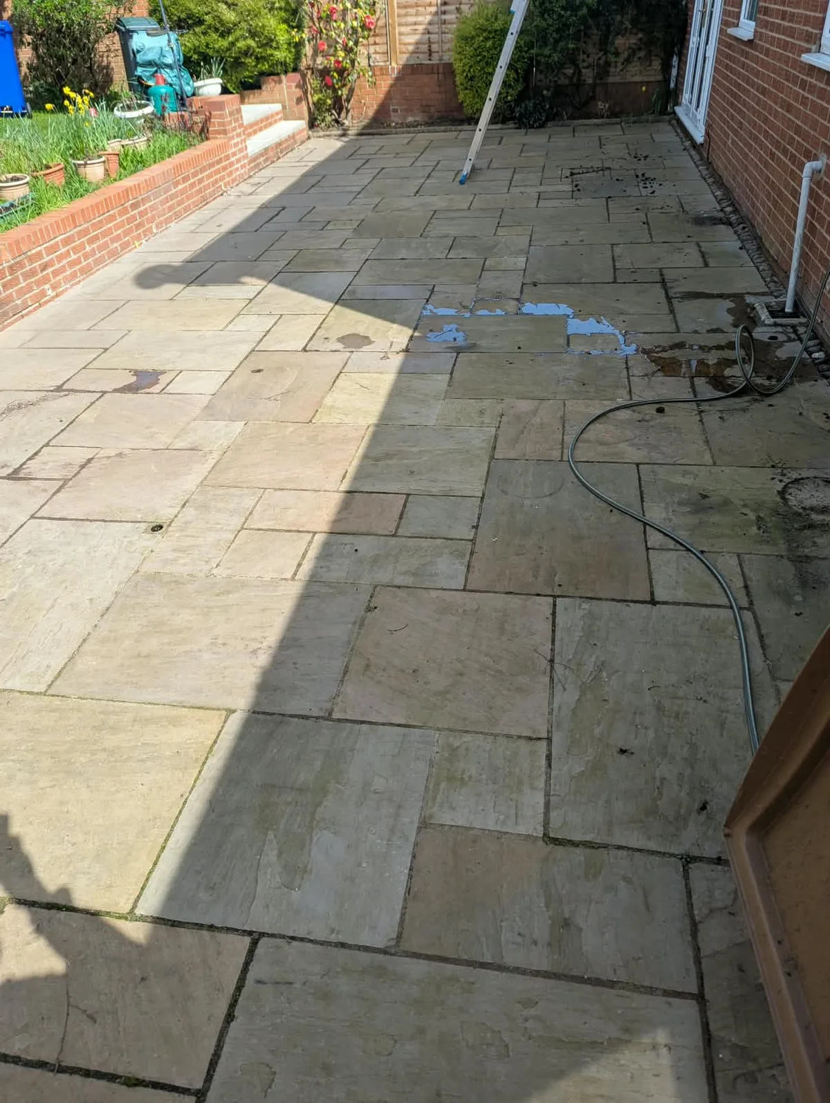 Patio paving at the Leek property before cleaning, with dirt across the surface.