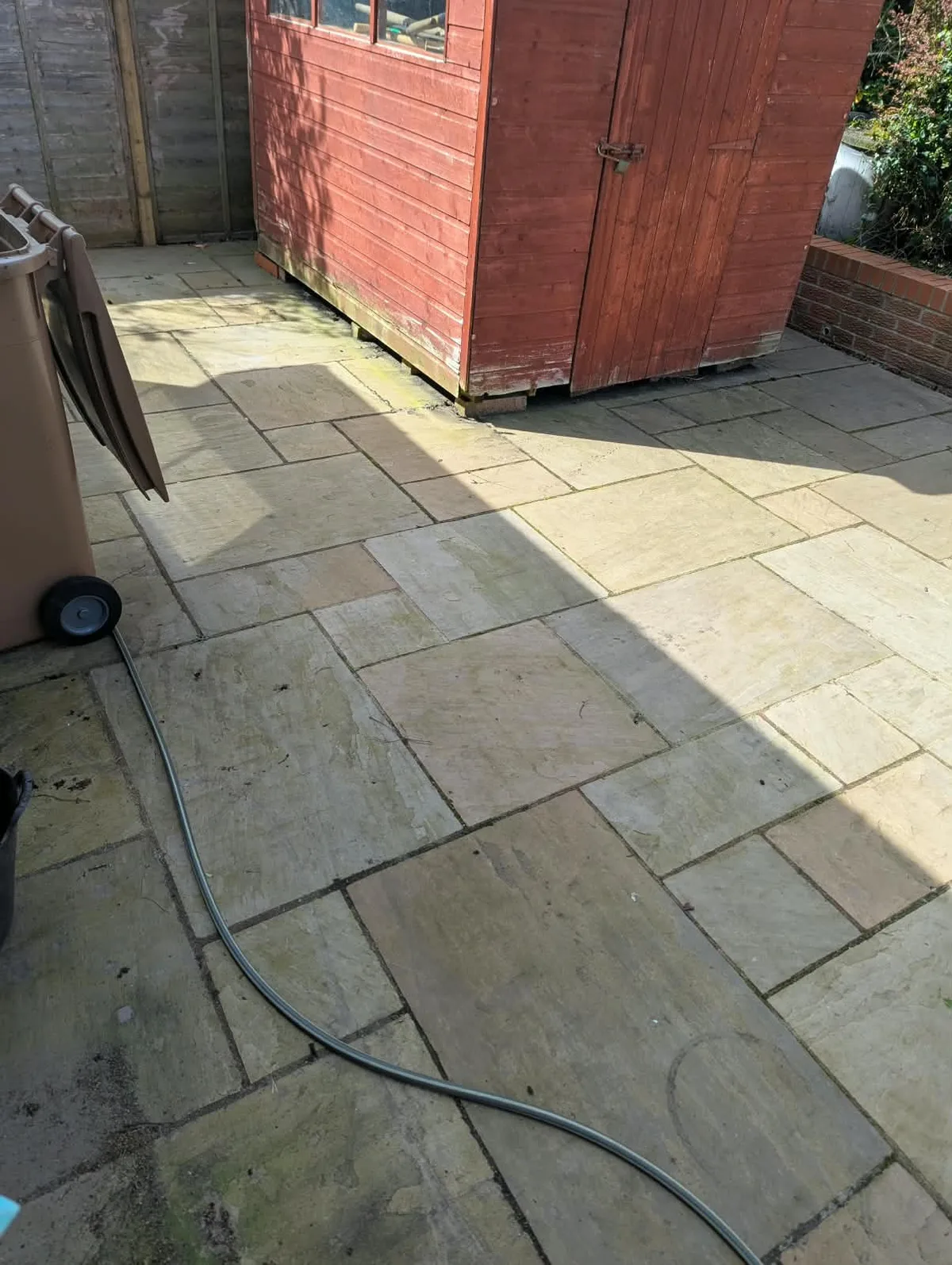 Paving beside the garden shed in Leek before cleaning.