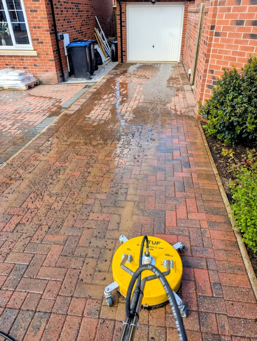 A rotary surface cleaner working across block paving
