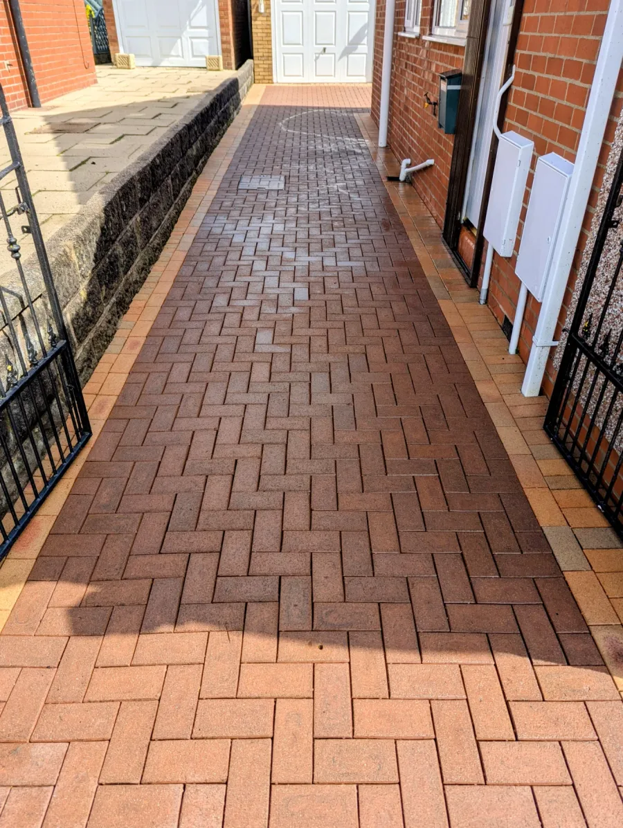 The same narrow block-paved side driveway after cleaning