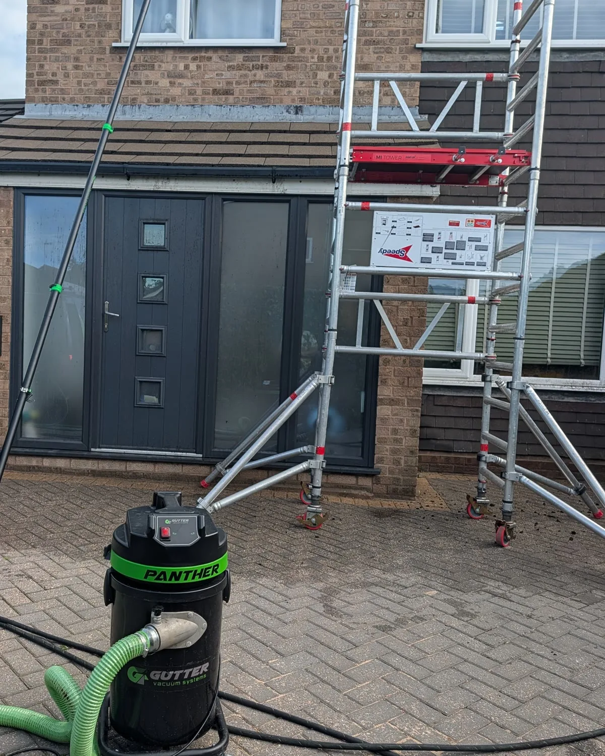 Mobile access tower, long reach pole and gutter vacuum set up safely at the Tean property.