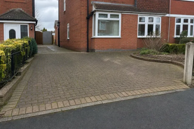 Wide photograph showing a complete block-paved driveway and its access route.