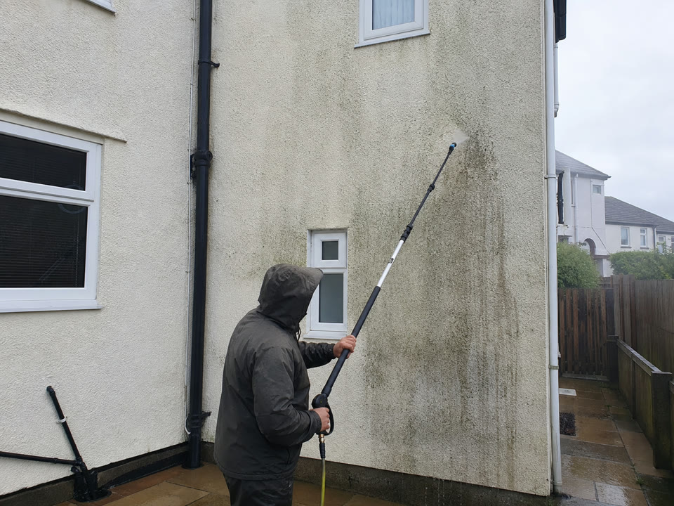 Representative image of a rendered wall being cleaned by a low-pressure process.